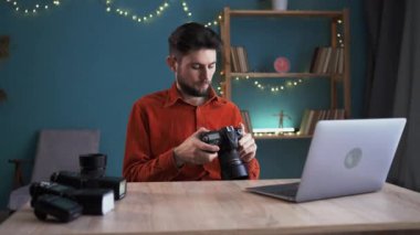 Masadaki ofiste çalışan fotoğrafçı kamerayı tutar, fotoğrafları bir dizüstü bilgisayara gönderir, kamera ekranındaki fotoğraflara bakar. Fotoğraf işi konsepti