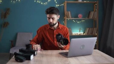 Bilgisayardan fotoğrafları aktaran bir adam ev ofisinde kamerayla çalışan bir fotoğrafçı, seçici odaklanma. Profesyonel fotoğrafçılık ve yaratıcı kariyer kavramı