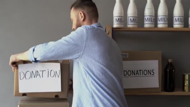 Mannelijke Vrijwilliger Die Voedsel Water Verpakt Donatie Liefdadigheidsdozen Close — Stockvideo