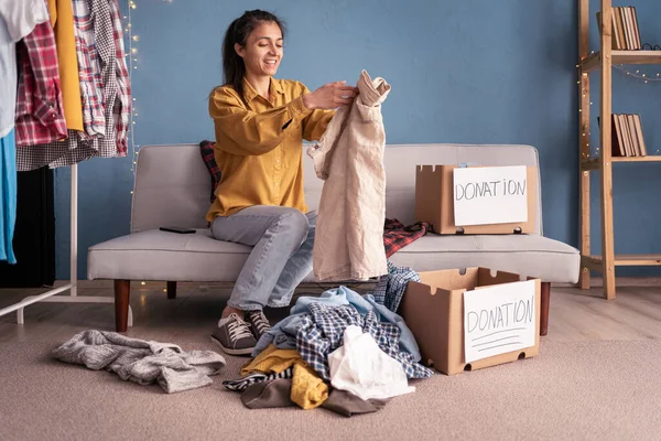 Женщина Разбирает Вещи Дома Упаковывает Коробку Пожертвованиями Полную Одежды Концепция — стоковое фото