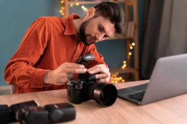 Ofisinde kamera ve dizüstü bilgisayarı olan profesyonel fotoğrafçı fotoğraf ekipmanı kullanıyor. Boşluğu kopyala