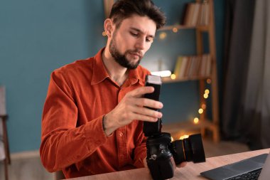 Fotoğrafçılar için online kurs izleyen bir fotoğrafçının portresi. Ofiste dijital kamera ekipmanı ve ayarları var. Boşluğu kopyala