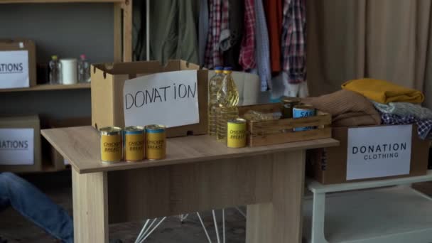 Уставший Волонтер Спящий Центре Пожертвований Среди Коробок Коробка Едой Столе — стоковое видео
