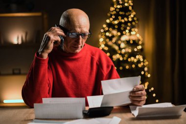 Yılbaşı tatilinde faturalarını ödemekten ya da postalarını geç saatlere kadar göndermekten korkan yaşlı bir adam. Xmas zamanı ve para. Boşluğu kopyala
