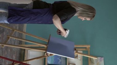 Yaratıcı sanatçı tuval ve dokuma sanatına uygulamak için macun ve spatula kullanarak resim yapıyor. Dikey video