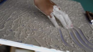 Dişi sanatçı ellerini tuvale koyup resim çizer, parmaklarıyla duygusal dokulu yağlı boya resim yapar. Ressam soyut modern sanat yaratıyor. Dikey video