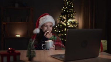 Mutlu çocuk dizüstü bilgisayar ekranına bakıyor, marshmallow yiyor, harika Noel hediyeleri görüyor ya da sinema sitesinde online Xmas filmi izliyor. Boşluğu kopyala