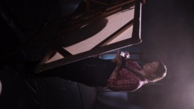 Karanlık sanat stüdyosundaki kadın ressam. Modern sanat eseri yaratmak için çalışan yetenekli genç bir sanatçı. Dikey video