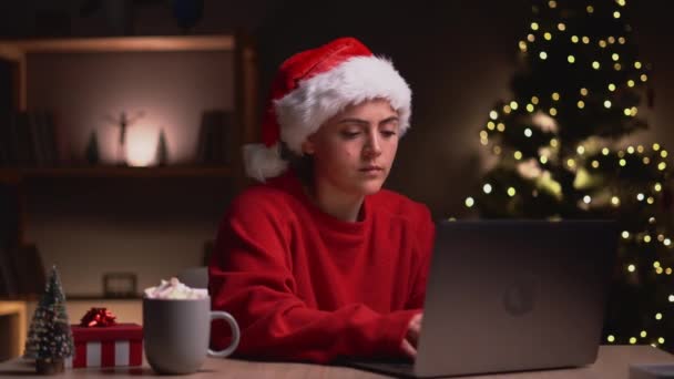 若い魅力的な女性は自宅でクリスマスイブにラップトップ上の電子メールを送信します スペースのコピー — ストック動画