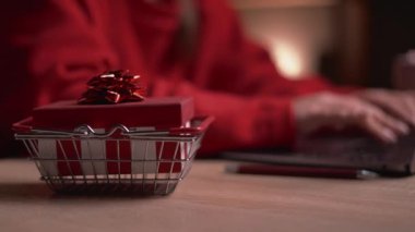 Noel alışverişi online konsept, satış ve indirimler kış tatilleri boyunca promosyonlar, evde online alışveriş. Dizüstü bilgisayarda hediyeyle yazı yazan kadın elleri. Yakın plan.