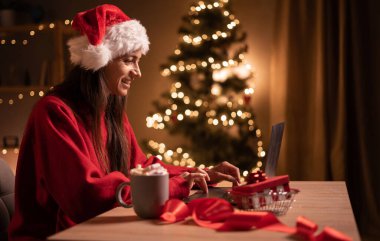 Bilgisayardan Noel arifesinde piyango kazanma ve sınıfta mutlu olma hakkında harika haberler alan neşeli sürpriz kadın. İnanılmaz bir şans, yeni yıl satışları ve alışveriş. Xmas indirimleri