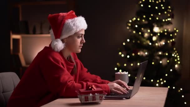 笑顔の女性は ラップトップで電子メールを送信し オンラインショッピング 自宅でクリスマスのイブに贈り物を準備します フリーランスは冬休みに働いています スペースのコピー — ストック動画