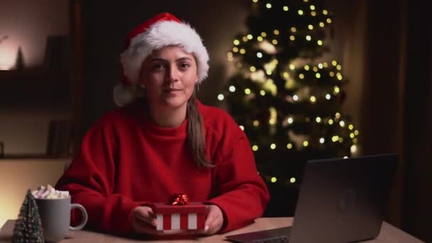 平安夜 快乐友善的女人拿着礼品盒 一边用笔记本电脑 一边在镜头前展示 复制空间 — 图库视频影像