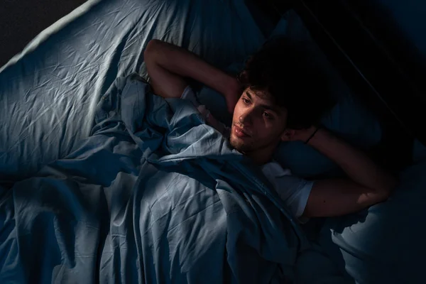 Напряженный Молодой Человек Пытается Спать Своей Постели Ночью Вид Сверху — стоковое фото