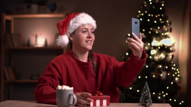 Mujer Joven Abriendo Regalo Navidad Sintiéndose Decepcionada Mientras Recibe Videollamadas — Vídeos de Stock