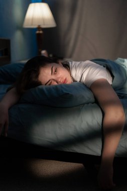 Depresyondaki bir kadının karamsar portresi. Yatakta acı çekiyor ve uykusuz bir şekilde uykusuzluk çekiyor. Yaşam problemi konsepti