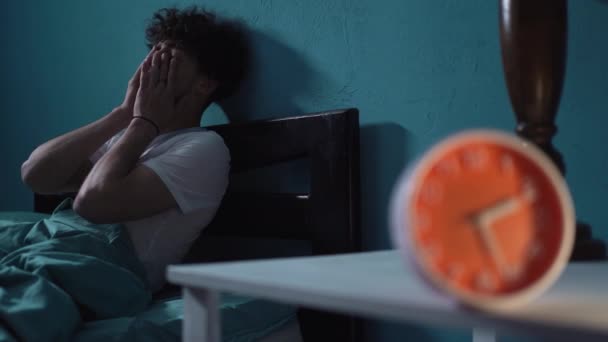 Δυστυχισμένος Νεαρός Αϋπνία Κάθεται Στο Κρεβάτι Δίπλα Στο Ξυπνητήρι Νύχτα — Αρχείο Βίντεο