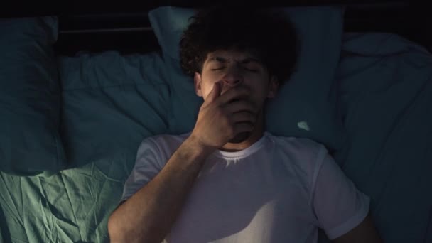 眠れないアラブ人男性のベッドで夜には 不眠症に苦しんであくびをする 就寝時と休息の概念 トップ表示 — ストック動画