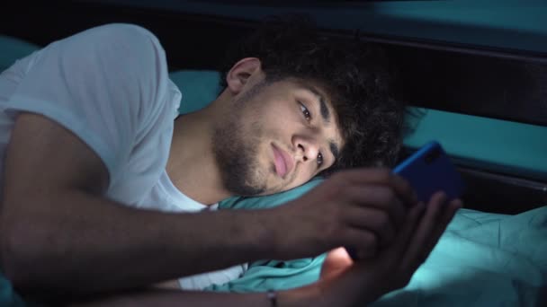 Zszokowany Młody Człowiek Patrząc Smartfona Łóżku Domu Facet Niespodziewaną Miną — Wideo stockowe