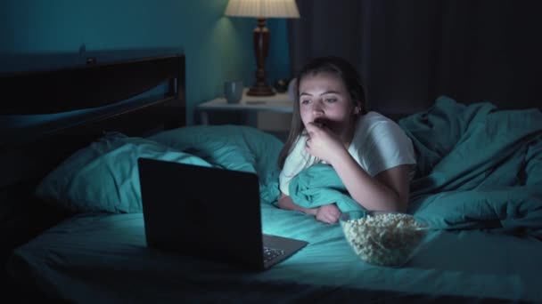 Щаслива Молода Жінка Їсть Попкорн Лежачи Ліжку Дивлячись Фільм Ноутбук — стокове відео