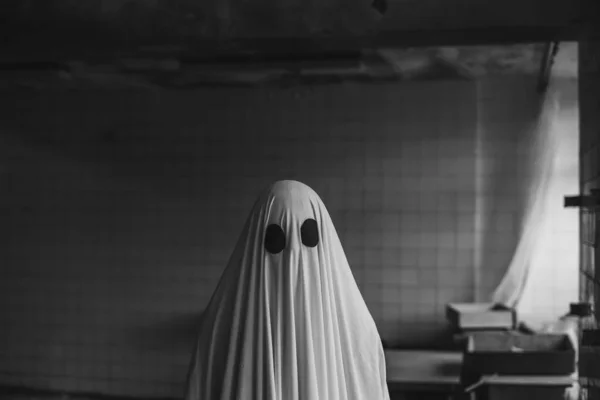 在废弃的房子里 鬼魂被一张白色的鬼皮覆盖着 万圣节概念 黑白照片 — 图库照片