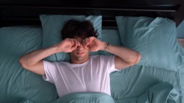 Sağlıklı uykudan uyanan olumlu bir adamın yatak odasındaki gece rüyalarından sonra tatmin olması. 4K