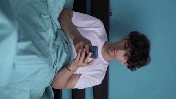 Arabic Young Man Bed Uses Smartphone Watches Social Networks Yawns — Stock Video