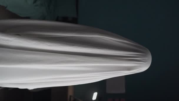 寝室に立って白いシートに幽霊のクローズアップ ハロウィンのコンセプト 垂直ビデオ — ストック動画