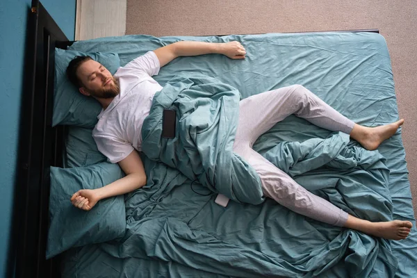 Beyaz Tenli Yakışıklı Genç Adam Akıllı Telefonuyla Yatakta Uzanıyor Uyku — Stok fotoğraf