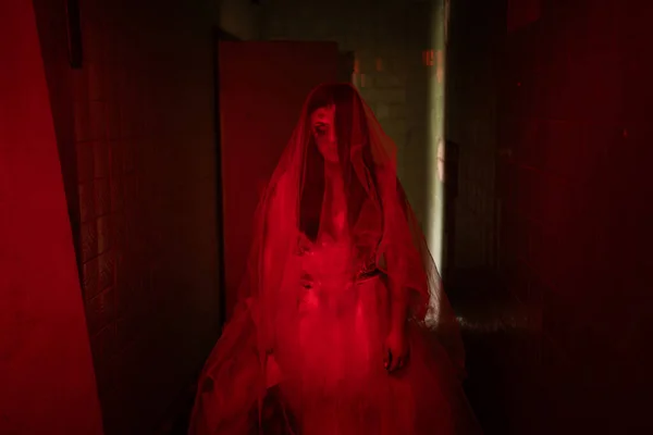 死者的新娘 穿着白色衣服的鬼魂女人穿过一座旧建筑或鬼屋 红色调的照片 复制空间 — 图库照片