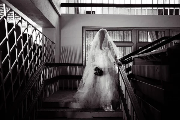 お化け屋敷の花嫁の幽霊 放棄された建物の階段に立つ白いドレスの謎の女性 ハロウィンのコンセプトのためのホラー背景 — ストック写真