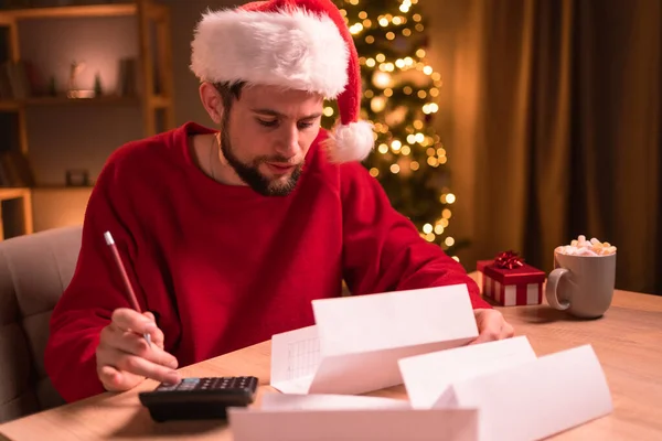 A Man Holds a Gift on His Office Desk at Christmas and New Year