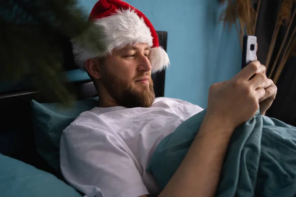 Glimlachende Man Santa Hoed Met Behulp Van Mobiele Telefoon Surfen — Stockfoto