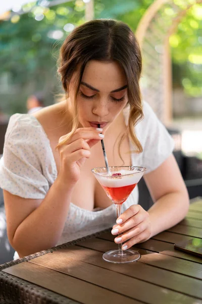 夏にレストランで友人と会うのを待っている間 若いスタイリッシュな女性がカクテルを飲んでいます 美しい女性は街のアウトドアライフスタイルをお楽しみください スペースのコピー — ストック写真
