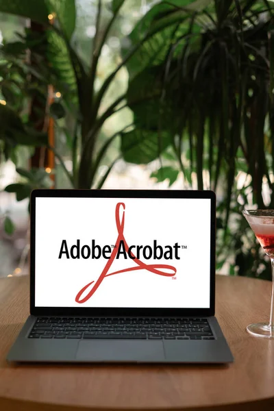 Odessa ウクライナ 2023年6月14日 Adobe Inc によって開発されたAdobe Acrobat アプリケーションソフトウェアおよびWebサービスのロゴが表示される夏のカフェのラップトップコンピュータ スペースのコピー — ストック写真