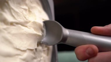 Vanilyalı dondurma kaşıkla konteynırdan çıkarıldı. Dikey video