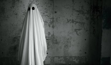 Terk edilmiş evin arka planında beyaz bir çarşafın içindeki hayalet. Siyah ve beyaz. Boşluğu kopyala