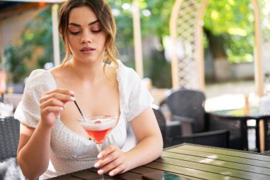 Bir restoranda kokteyl içen güzel bir kızın portresi. Yaz aylarında sıcak ülkelerde dinleniyor. Boşluğu kopyala
