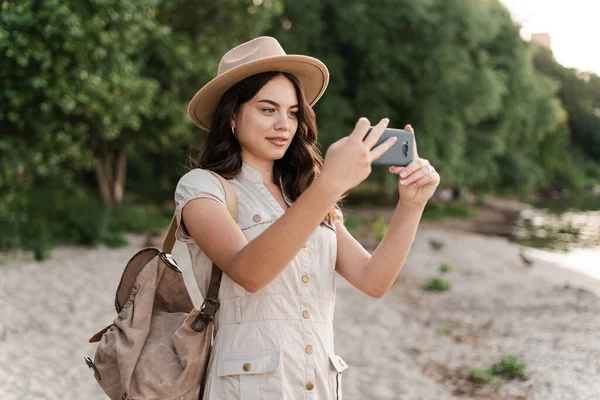 Sırt Çantalı Bayan Turist Akıllı Telefon Tutuyor Güzel Sahil Günbatımının — Stok fotoğraf