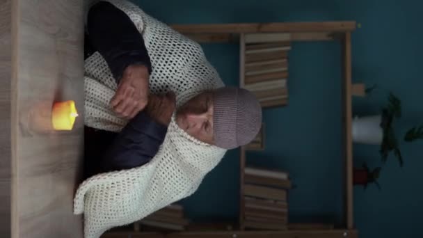 Oude Man Gekleed Een Warme Winterjas Zit Thuis Aan Een — Stockvideo