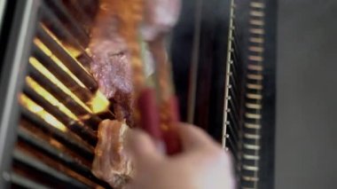 Domuz eti ve tavuk bifteği ızgarada pişiyor dumanla, barbekü et yaz konseptiyle. Dikey video