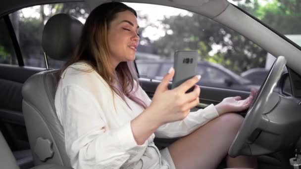 在路上塞车的女司机打电话 手机里有一个视频电话 朋友们都会在夏天去旅行 侧视图 — 图库视频影像