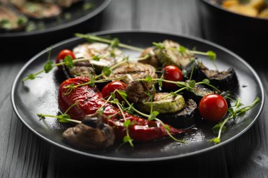 Izgara sebzeler, domates, siyah arka planda kabak kırmızısı. Boşluğu kopyala