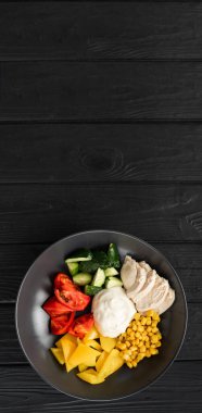 Ketogenik, keto besin konsepti. Kızarmış tavuk fileto ve taze sebze salatası, salatalık, biber ve mısır. Tabakta salata ile tavuk eti. Sağlıklı yiyecekler. Dikey afiş. Boşluğu kopyala