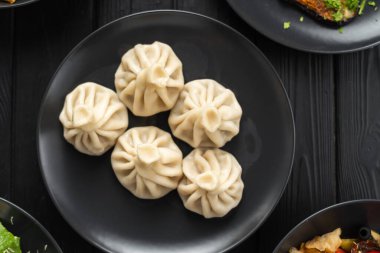 Khinkali 'nin koyu ahşap tabakta üst görüntüsü. Boşluğu kopyala