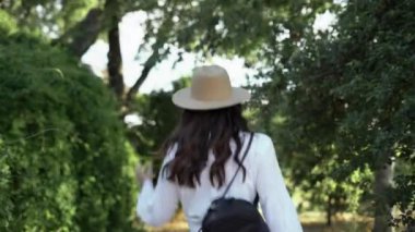 Çekici genç bir kadın yaz tatilini dışarıda, parkta gün batımıyla geçiriyor, akşamları yürüyor. Yakın plan.