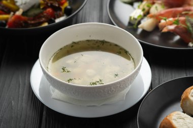 Siyah kasede sebzeli tavuk suyu çorbası. Koyu ahşap arka plan. Yukarıdan bak. Boşluğu kopyala