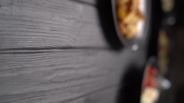 フェタチーズと新鮮なギリシャのサラダ トマト レストランで黒テーブルの上に提供する黒オリーブと玉ねぎ 垂直ビデオ — ストック動画
