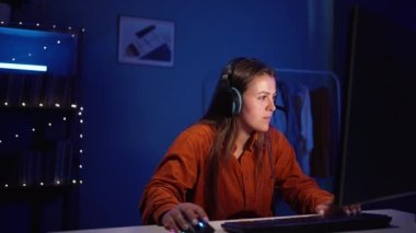 Happy girl gamer participation play video game neon lights in living room at night. Esport streaming game online, winner concept. Copy space