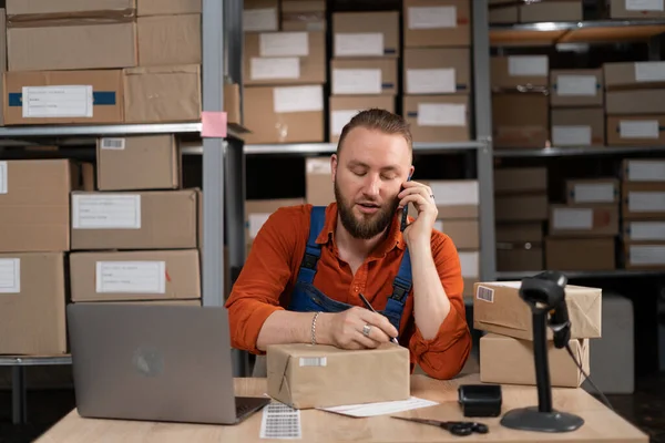 Warehouse inventory management. Courier shipment transportation. Warehouse worker is writing on the box and talking with client about shipment. Copy space
